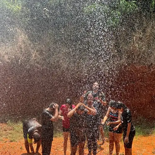 A guest mid mud bath, laughing, coated to the elbows.